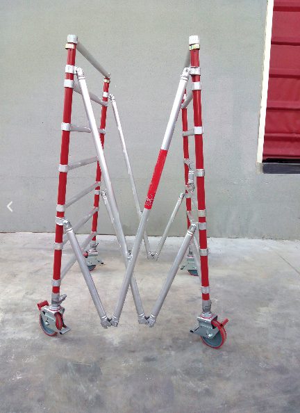 Foldable metal ladder with wheels and red accents.